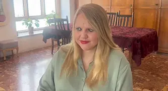 A woman sitting on a chair with a table behind her