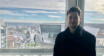 A man stands in front of a window