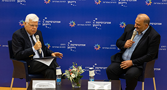 אנשים יושבים על כסאות על במה בפאנל