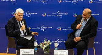 אנשים יושבים על כסאות על במה בפאנל