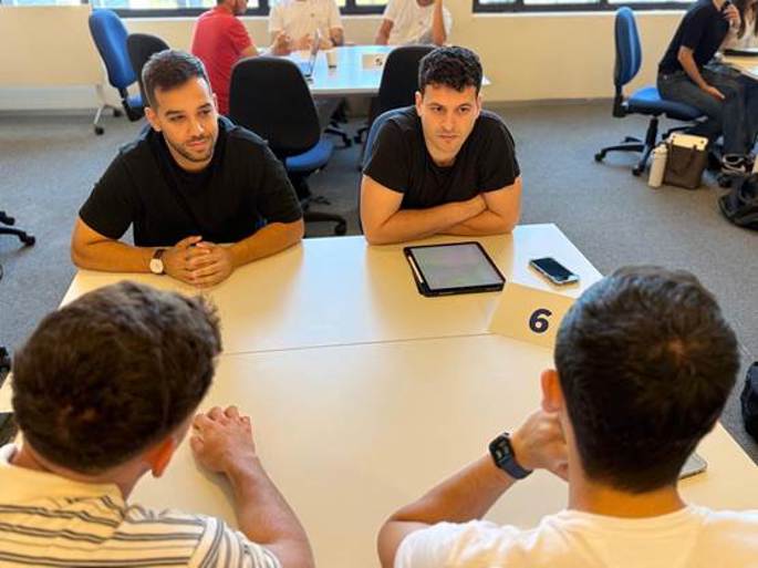 A group of men sitting at a table
AI-generated content may be incorrect.