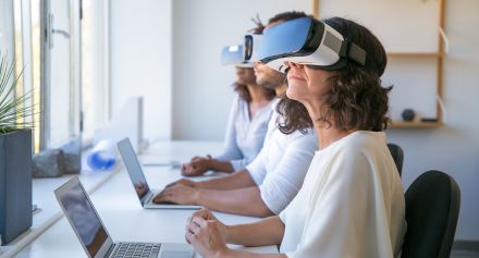 אנשים יושבים מול לפטופים עם משקפי VR