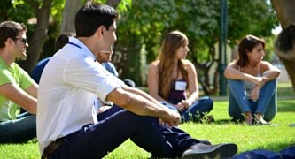Picture of orientation students sitting on the grass