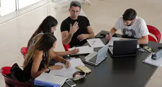 אנשים יושבים על מסמכים ולומדים