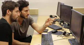 שני גברים יושבים מול מסך מחשב