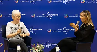 אנשים יושבים על כסאות על במה בפאנל