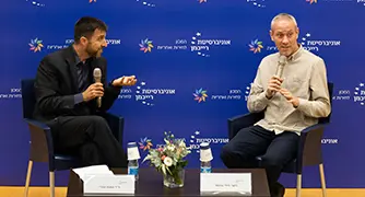 אנשים יושבים על כסאות על במה בפאנל