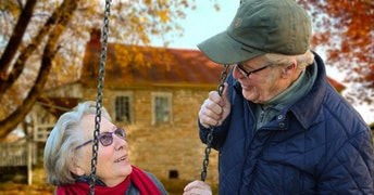 זוג מבוגרים מסתכלים אחד על השנייה בנדנדה